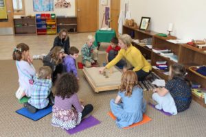 Children setting-up scripture scene in sandbox in Worship Center